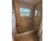 An inviting bathroom featuring a tiled shower and bathtub combination with window view at 795 Temple Ave, Orange City, FL 32763