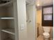Modest bathroom featuring a shower, toilet, window, and built-in shelving for storage at 795 Temple Ave, Orange City, FL 32763