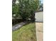 Exterior view of home and driveway with mature trees and foliage at 795 Temple Ave, Orange City, FL 32763