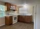 Traditional kitchen with wood cabinets, white appliances, and laminate floor at 795 Temple Ave, Orange City, FL 32763