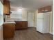 Traditional-style kitchen with wood cabinets, white appliances, and new flooring at 795 Temple Ave, Orange City, FL 32763