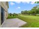 A large backyard with a concrete patio is lined with greenery and tall trees at 806 Sterling Spring Rd, Orlando, FL 32828