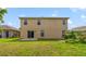 A backyard features a grassy lawn, a small patio and a two-story home at 806 Sterling Spring Rd, Orlando, FL 32828