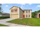 Two-story home with a neutral color scheme, red shutters, well-maintained lawn, and an attached garage at 806 Sterling Spring Rd, Orlando, FL 32828