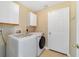 Well-lit laundry room with washer, dryer, and ample cabinet space at 806 Sterling Spring Rd, Orlando, FL 32828