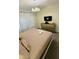 Relaxing bedroom featuring a queen-size bed, TV, and a stylish modern light fixture at 851 Drop Shot Dr, Davenport, FL 33896