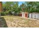 Generous backyard featuring weathered storage sheds and mature trees, with a partially fenced perimeter for privacy at 1111 Liberty Ave, Mount Dora, FL 32757