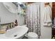 Cozy bathroom features patterned shower curtain, modern fixtures, glass shelves, and round mirror at 1111 Liberty Ave, Mount Dora, FL 32757