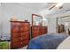 This bedroom features stylish wooden dressers, mirror, and closet, offering ample storage space at 1111 Liberty Ave, Mount Dora, FL 32757