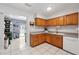 Bright kitchen with wood cabinets, tile floors, and stainless-steel dishwasher at 1111 Liberty Ave, Mount Dora, FL 32757