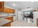 Open kitchen and dining area with wood cabinets, tile floors, and modern appliances at 1111 Liberty Ave, Mount Dora, FL 32757