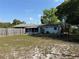 Spacious backyard featuring lush green grass, a screened-in porch, and play structure at 11314 Huggins St, Leesburg, FL 34788