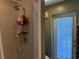 Bright bathroom featuring a shower, shelving, and a door to the outside at 11314 Huggins St, Leesburg, FL 34788