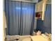 Bathroom with blue walls, white vanity, and combination shower and tub at 11314 Huggins St, Leesburg, FL 34788