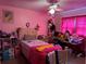 Bright bedroom with playful decor, fan, and pink walls and curtains at 11314 Huggins St, Leesburg, FL 34788