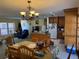Open kitchen and dining area featuring tile floors, kitchen island, and granite countertops at 11314 Huggins St, Leesburg, FL 34788