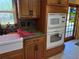 Modern kitchen featuring stainless appliances, granite counters, wooden cabinets, and tile floors at 11314 Huggins St, Leesburg, FL 34788