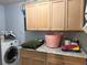Well-equipped laundry room with modern washer and dryer, storage cabinets and granite countertops at 11314 Huggins St, Leesburg, FL 34788