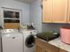 Well-equipped laundry room with modern washer and dryer, storage cabinets and granite countertops at 11314 Huggins St, Leesburg, FL 34788