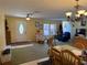 Open-concept area combines living, dining, and kitchen, offering versatile living space with tile and carpet flooring at 11314 Huggins St, Leesburg, FL 34788
