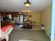 Open-concept living room with connected kitchen, dining space, tile floors, and natural light, bright yellow walls at 11314 Huggins St, Leesburg, FL 34788