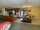 Bright open-concept living room connected to the kitchen featuring a dining space and large windows at 11314 Huggins St, Leesburg, FL 34788