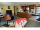 Open concept living room featuring tile floors and a kitchen with wood cabinets and island at 11314 Huggins St, Leesburg, FL 34788