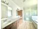 Modern bathroom featuring double sinks, wood cabinets, large shower, and separate tub at 131 Addle Hill Ct, Deland, FL 32720