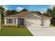 Charming one-story home with a three-car garage, stone accents, a well-manicured lawn, and professional landscaping at 1359 Morning Walk Dr, Ormond Beach, FL 32174
