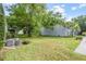 Exterior view of backyard with lush green grass, mature trees, and patio at 141 Lewfield Circle # 141, Winter Park, FL 32792