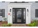 Close-up of the front door with decorative sidelights and surrounding landscaping at 141 Lewfield Circle # 141, Winter Park, FL 32792