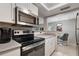 Kitchen featuring modern stainless steel appliances and a pass-through to the adjacent dining room at 141 Lewfield Circle # 141, Winter Park, FL 32792
