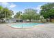 Community pool surrounded by lounge chairs, lush trees, and a paved deck, perfect for relaxing and enjoying the outdoors at 141 Lewfield Circle # 141, Winter Park, FL 32792