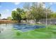 Well-maintained tennis court with green and blue surface, enclosed by a fence and surrounded by mature trees at 141 Lewfield Circle # 141, Winter Park, FL 32792
