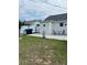 Spacious backyard with a well-maintained lawn, a patio area with seating, and mature trees at 1620 Hialeah St, Orlando, FL 32808