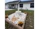 Landscaped front yard featuring a decorative fountain, colorful plants, and manicured grass at 1620 Hialeah St, Orlando, FL 32808