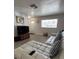 Living room features a modern sofa, a large window, and wood-look tile flooring at 1620 Hialeah St, Orlando, FL 32808