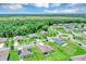 An aerial view of neighborhood homes, lush landscaping, and verdant green space at 16406 Blooming Cherry Dr, Groveland, FL 34736