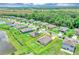 Aerial view of home surrounded by green lawns, lush greenery, and nearby community streets at 16406 Blooming Cherry Dr, Groveland, FL 34736