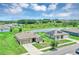 Aerial view of home with a pond view, landscaped yard, and houses with solar panels on the roofs at 16406 Blooming Cherry Dr, Groveland, FL 34736