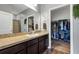 Well-lit bathroom featuring a large mirror, vanity, and a glimpse into the closet at 16406 Blooming Cherry Dr, Groveland, FL 34736