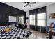 Modern bedroom with dark walls, checker bedding, and a ceiling fan at 16406 Blooming Cherry Dr, Groveland, FL 34736