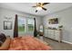 Relaxing bedroom with fan, dresser, and natural light from the window at 16406 Blooming Cherry Dr, Groveland, FL 34736