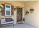Inviting front porch with a cozy bench, decorative plants, and a welcoming door at 16406 Blooming Cherry Dr, Groveland, FL 34736