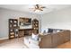 Comfortable living room featuring wood floors, large sectional sofa, media center with built in shelving, and a ceiling fan at 16406 Blooming Cherry Dr, Groveland, FL 34736