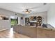 Spacious living room with wood floors, large sectional sofa, ceiling fan and sliding glass doors to the backyard at 16406 Blooming Cherry Dr, Groveland, FL 34736