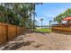 Backyard features a wooden fence, mulch, and access to the lake and a dock at 1700 Lake Markham Rd, Sanford, FL 32771
