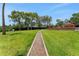 Grassy backyard features a mulch path that winds to a lakefront entertainment deck at 1700 Lake Markham Rd, Sanford, FL 32771