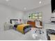 Bright bedroom features a bed with yellow throw, a large window, and desk area at 1700 Lake Markham Rd, Sanford, FL 32771