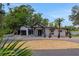 Stunning front exterior of the home with a circular driveway, palm trees, and modern design elements at 1700 Lake Markham Rd, Sanford, FL 32771